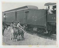 [Tom Mix on horse roping train engineer from "The Texan"]