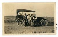 [2 men and 2 women sitting on running board of an automobile]