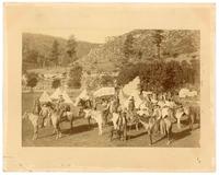 [Group of cowboys on horseback posing for photograph in their camp]
