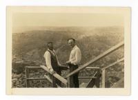 [2 men standing on wooden steps at what appears to be the Grand Canyon]