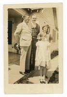 [2 men, a woman, and a young girl standing on a front porch]