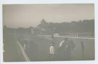 [Cowboys, cowgirls, and horses on race track]