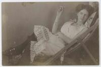 [Woman posed in camisole, smoking in a chair]