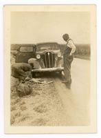 [man and woman standing in front of a car]