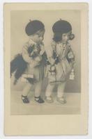 [Male and female dolls posed together holding packages with berets]