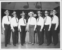 Johnnie Lee Wills and band [the band is posing in front of a stage]