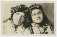 [Two Hawaiian women with leis and hair garlands]