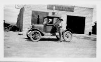 [Model T-type Car in front of garage]