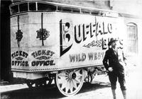 Buffalo Bill, William F. Cody, stands in front of one of his show wagons