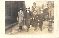 [2 cowboys and 2 women walking down a city street]