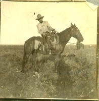 [Cowboy on horseback in profile]