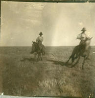 [Two Cowboys riding on horses]