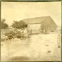 [Barn with horse tied to fence]