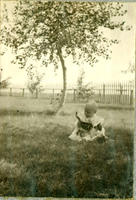 [Baby in backyard with cat on lap]