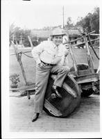 Bob Wills [leaning on old wooden cart with wooden wheels]