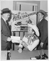 Johnnie Lee Wills [with 2 men and a sign advertising the Johnny Lee Will Tulsa Stampede]